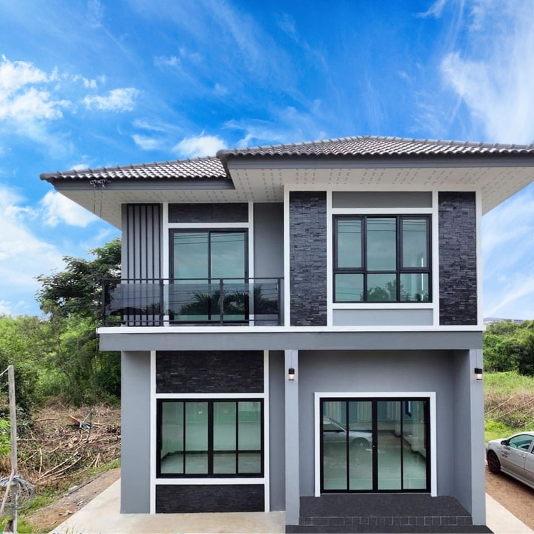 แบบบ้าน SK-45: บ้านสองชั้นสไตล์โมเดิร์น-ทรอปิคอล ผสมผสานความสวยงามและการใช้งานที่ลงตัว แบบบ้าน SK-45 โดดเด่นด้วยการออกแบบในสไตล์ โมเดิร์น-ทรอปิคอล (Modern-Tropical) ที่ผสมผสานความทันสมัยเข้ากับการออกแบบเพื่อรับกับสภาพภูมิอากาศเมืองร้อนของไทย บ้านหลังนี้เหมาะสำหรับครอบครัวที่ต้องการบ้านที่โปร่งสบาย เน้นการใช้พื้นที่อย่างคุ้มค่า พร้อมเพิ่มพื้นที่พักผ่อนทั้งภายในและภายนอกบ้าน